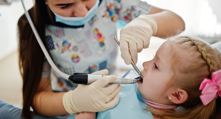 Little baby girl at dentist chair. Children dental.