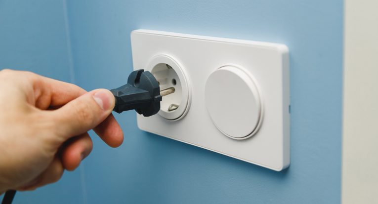 Inserting power cord receptacle in wall outlet