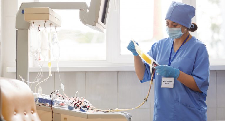 Nurse in uniform preparing dropper for donor she is in blood donation laboratory